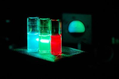 Synthesized QDs suspended in solvents under laser irradiation image